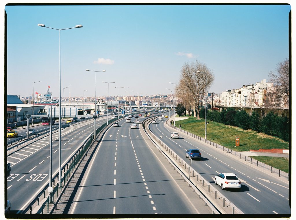 Aerial view of a bustling expressway in Istanbul with moving vehicles and cityscape.